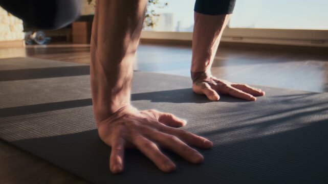 Strong hands press on yoga mat during balance work in morning