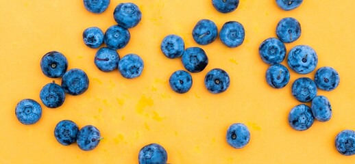 Fresh blueberries on a vibrant yellow background