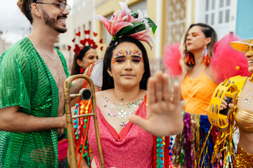 Woman raising her hand in a stop gesture to reject harassment during a Brazilian carnival street...