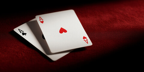 Obraz premium A pair of aces cards on a red surface with a dramatic light. Two playing cards, Ace of spades and Ace of hearts, lie side by side on a dark red table, ready for a winning play.