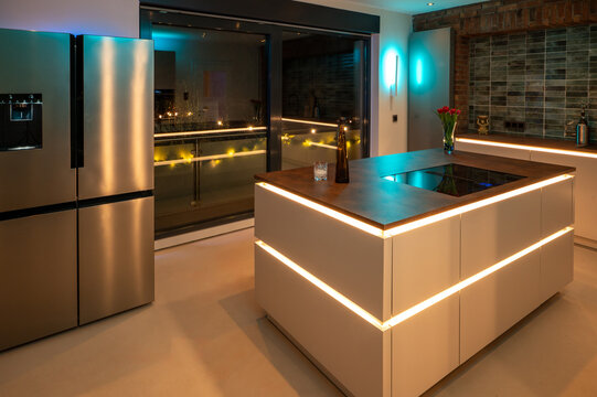 Luxury Kitchen Interior Design: Side-by-Side Refrigerator and Seamless Flooring with modern LED Ambient Lighting and Corten Steel Countertop