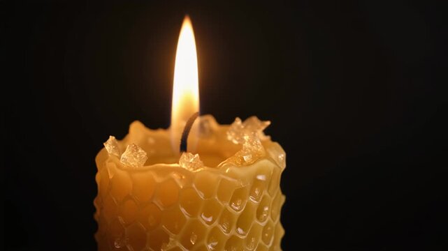 Close-up of a beeswax candle flame and crystallizing wax