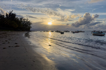 Peaceful sunset over Tamarin Bay with traditional fishing boats on the calm water in Mauritius