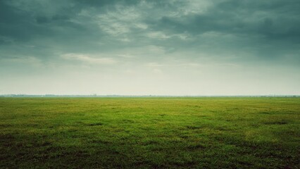 Obraz premium Green field under a stormy sky