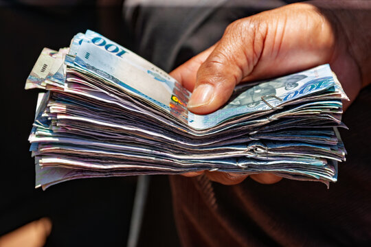 Close-up of Person Holding Wads of Botswana Pula Banknotes, Traditional Lobola Bride Price Payment