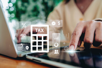 Hand using digital tax calculator interface on tablet and laptop with financial icons representing online tax filing, accounting, business finance management, and financial technology concept