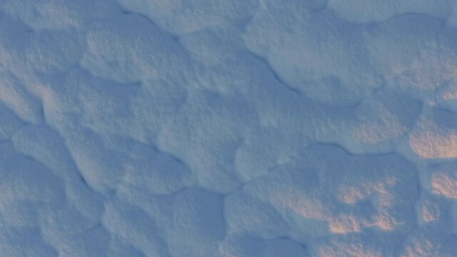 Ripresa aerea verticale dall'alto da drone di neve e ghiaccio con texture astratte in inverno. Movimento dal basso verso l'alto