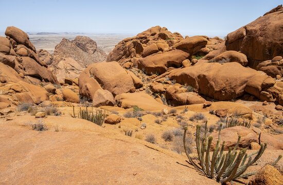 Sublime rock formations in the vast desert landscape of Spitzkoppe with isolated vegetation, Spitzkoppe, Erongo, Namibia