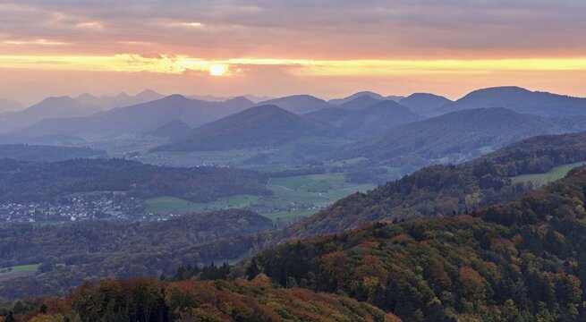 View of an autumnal forest from the Gisliflue, behind the Jurassic foothills in the light of the setting sun, Talheim, Canton, Aargau, Switzerland