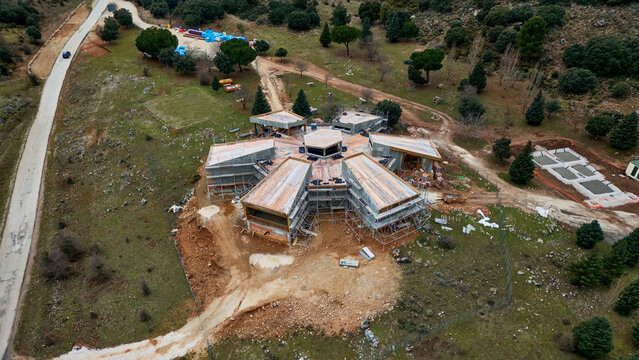 Aerial view of a unique star-shaped structure emerging amidst the raw landscape, its angular lines contrasting with the soft, undulating hills, Conejeras, Andalucia, Spain.