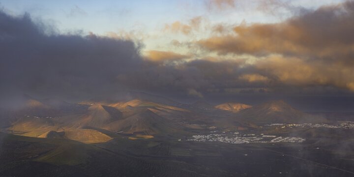 Panorama at sunrise from the Montana de Guardilama to the wine-growing area La Geria, behind it the villages Uga and Yaiza, Lanzarote, Canary Islands, Spain