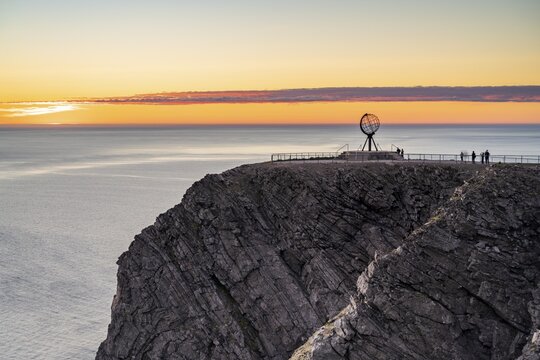 Rock cliff of the North Cape with steel globe at midnight sun, Nordkapp, Finnmark, Norway