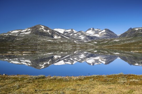 Mountains reflected in Lake Tyin, Jotunheimen National Park, Norway