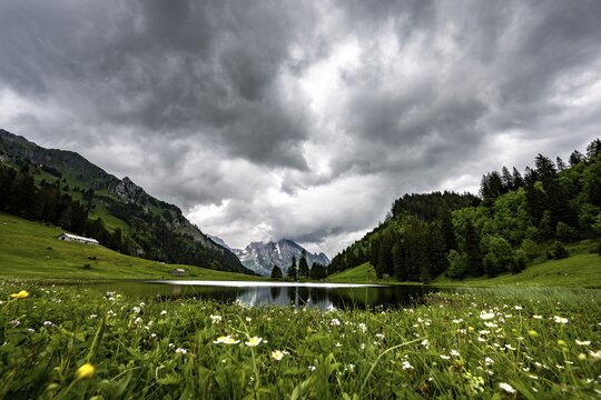 Gr&ouml;ppelensee with reflection of the Altmann summit in the background under a threatening cloudy sky, Wildhaus, Appenzell, Switzerland