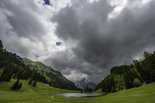 Gr&ouml;ppelensee with Altmanngipfel in the background under a threatening cloudy sky, Wildhaus, Appenzell, Switzerland
