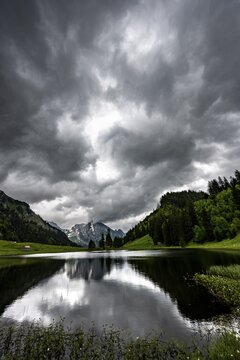 Gr&ouml;ppelensee with reflection of the Altmann summit in the background under a threatening cloudy sky, Wildhaus, Appenzell, Switzerland