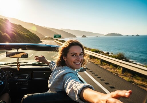 Freedom concept with a woman in a convertible car riding along the sea.