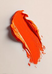 Vivid orange paint stroke on a neutral background, capturing texture and light