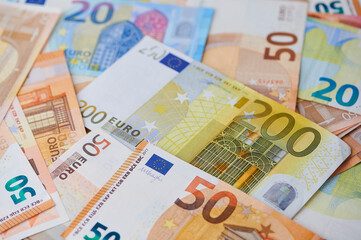 Various euro notes are seen together on a table.