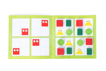 Open book and colorful pieces of geometrical sudoku for children isolated on white, top view