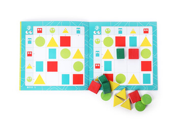 Fototapeta premium Open book and colorful pieces of geometrical sudoku for children isolated on white, top view