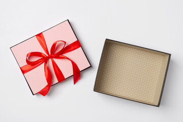 Open gift box with red ribbon on white background, top view