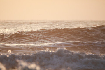 朝焼けに染まる波