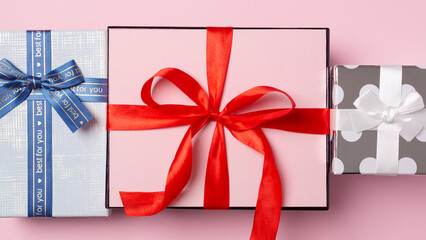 Gift boxes on pastel pink background, top view