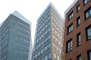 Obraz premium Three modern residential buildings with grid windows one in red brick and two in concrete facades architecture apartment construction urban exterior property housing transparent background