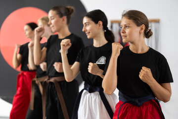 Women in black T-shirts during martial arts training in the gym