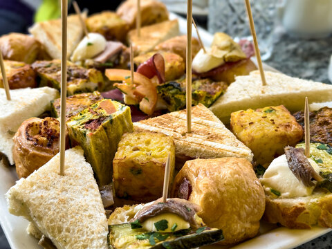 Italienische Aperitivo-Platte mit Tramezzini, Frittata und Antipasti in einer r&ouml;mischen Bar