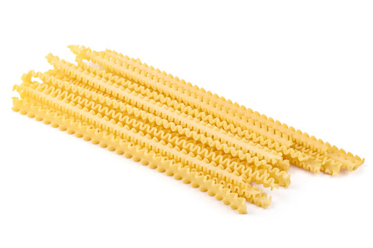 Golden yellow mafaldine pasta, neatly arranged in parallel rows, awaiting preparation for a delicious Italian meal, isolated on white background