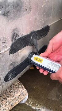 Leak stopping paste with handheld moisture meter checking damp concrete wall for plumbing seepage water damage repair basement waterproofing mold prevention and home inspection maintenance