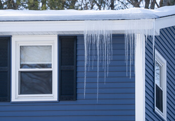 winter house with icicle and snow on the roof