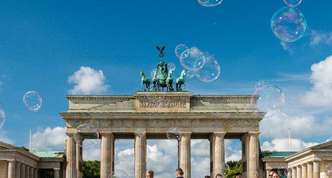Germany, Berlin.  Large soap bubbles floating above Brandenberg Gate