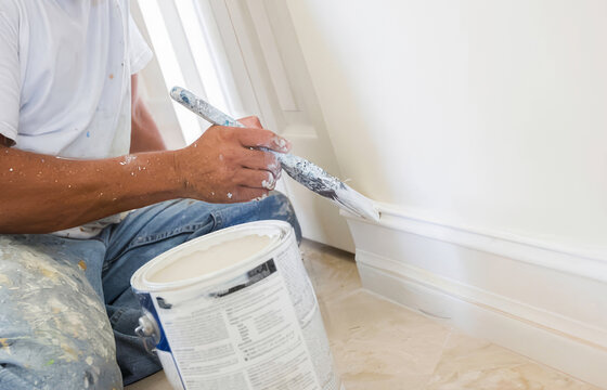 Painter Applying Fresh Paint to Baseboard Trim During Interior Home Renovation
Close-up of a painter brushing fresh paint onto a construction interior painter portrait