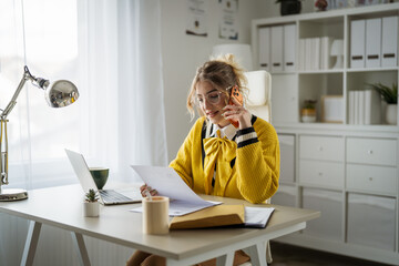 Smiling woman working from home having phone call