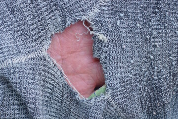 a piece of gray cloth on old torn clothes with a big  hole