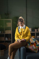 Fototapeta premium Young woman enjoying quiet time reading book at home