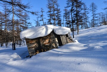 
Old Wooden Shack Covered in Deep Snow