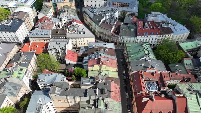 Low altitude aerial flyover of Rynek Gł&oacute;wny Square with St. Mary&rsquo;s Basilica and historic Old Town architecture, Krak&oacute;w, Poland