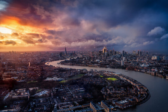 Elevated view of the cityscape of London, UK, with dramatic cloudscape, sunshine and rainfall during sunset time