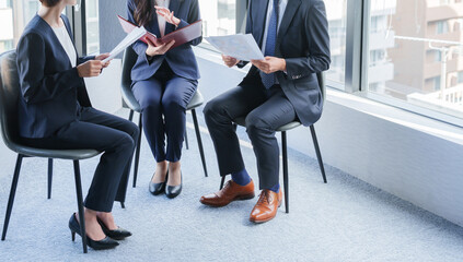 紙資料を持って会議するビジネスパーソン