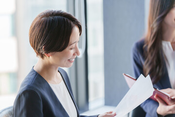 紙資料を持って会議するビジネスパーソン