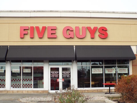 Nepean, ON, Canada-July 13,2025: A close-up view of the "Five Guys" exterior sign and storefront at 324 W Hunt Club Rd.
