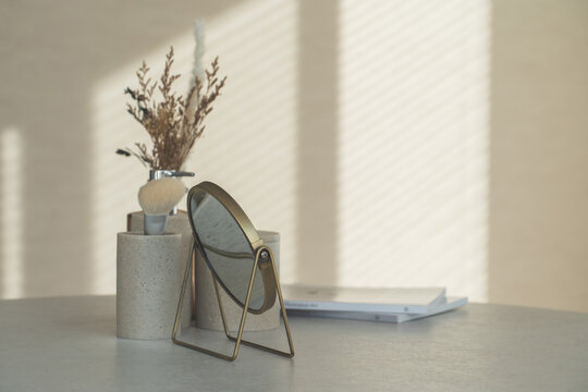 Makeup tools, cosmetics, makeup, and a tabletop mirror on the table