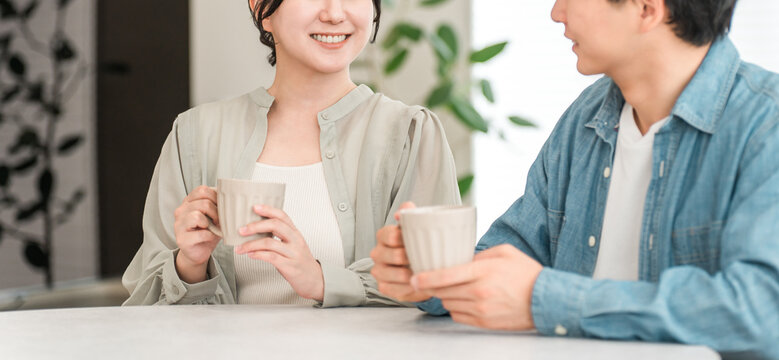 Couple having a conversation while drinking hot drinks at the dining table