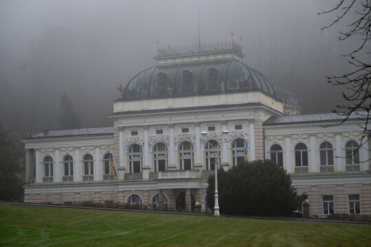 Historic neo-Baroque spa building in Marianske Lazne shrouded in thick fog