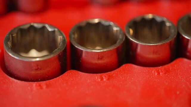 close-up of metric tools sockets where an indecisive hand grabs a socket with fingers that eventually chose metric size 18mm socket