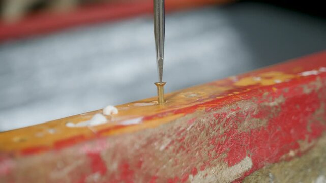 Screwing slotted brass screw through fiberglass boat gunwale